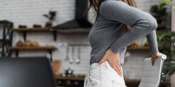 side view woman having backache while working from home 2